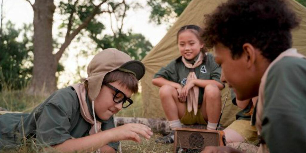 gruppo di bambini attorno a una tenda impegnati in giochi da tavolo per bambini plusdotati