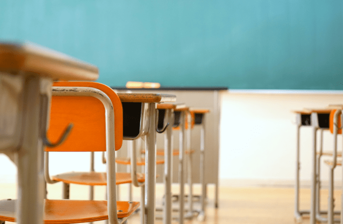 Banchi di scuola vuoti in un’aula di scuola superiore, contesto educativo legato alla plusdotazione scuole superiori